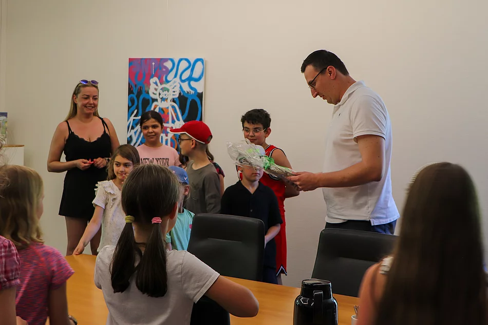 Bürgermeister Patrick Klose hält ein Geschenk in Händen.