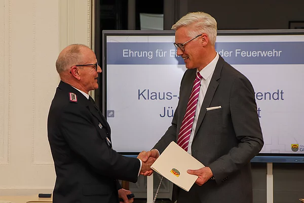 Jürgen Kumpert und Rainhard Zug geben sich zur Gratulation die Hand.