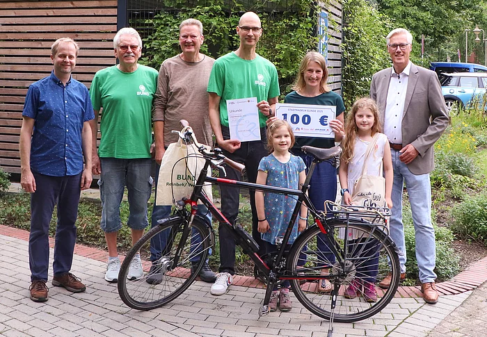 Eine Gruppe steht an einem Fahrrad.