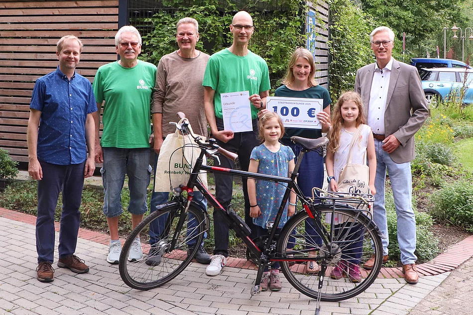 Eine Gruppe steht an einem Fahrrad.