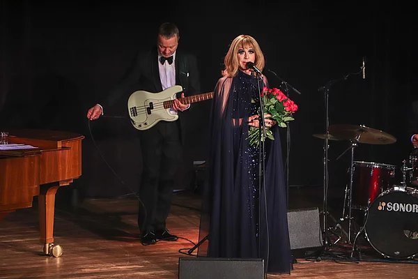 Tim Fischer hat einen Strauß rote Rosen in den Händen