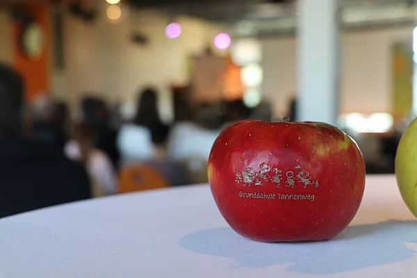 Ein Apfel mit dem Logo der Grundschule Tannenweg.