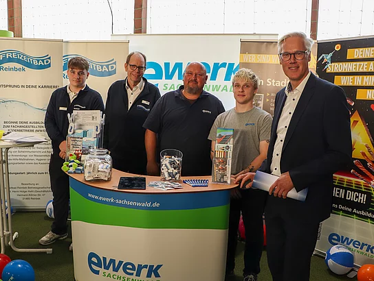 Menschen stehen an einem Messestand