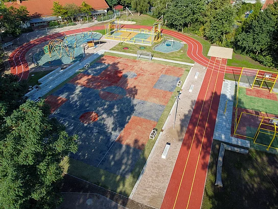 Die Laufbahn des Sportplatzes hat viele Kurven - von oben fotografiert.