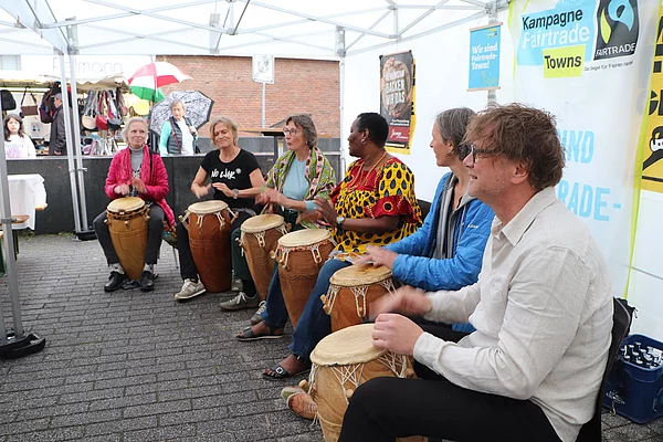 Eine Trommelgruppe sitzt im Halbkreis und trommelt