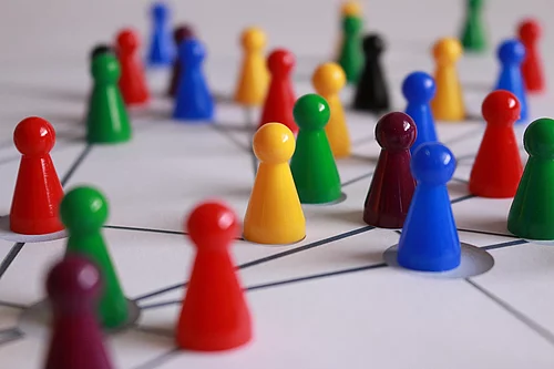 Kleine bunte Spielfiguren stehen auf verbundenen Linien und formen ein Netzwerk
