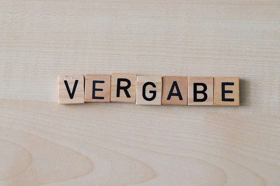 Holzplättchen formen das Wort Vergabe