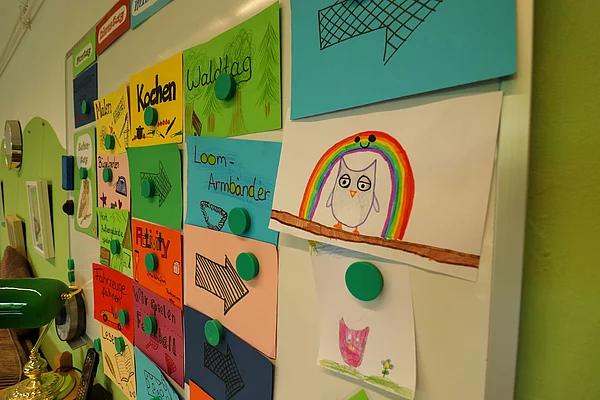 An einer Wand hängen viele Zettel mit Aufgaben für die Eulengruppe im Hort.