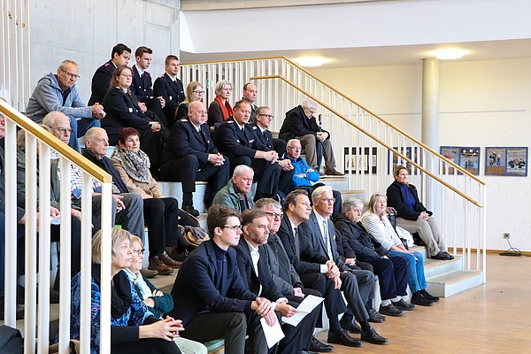 Publikum sitzt auf einer Treppe.