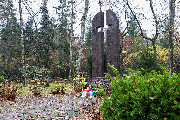 Das Ehrenmal aus dunkelrotem Granit besteht aus zwei Hälften. Es ist so geformt, dass in der Mitte ein Kreuz aus Luft entsteht.
