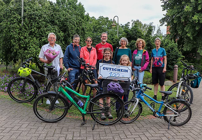 Eine Gruppe von Menschen steht vor Fahrrädern.