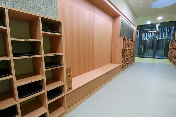 An einer Wand sind Fächer für die Straßenschuhe der Kinder.