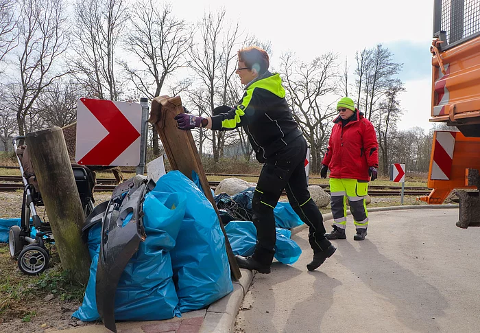 Müllsäcke werden auf die Ladefläche eines LKW geladen.