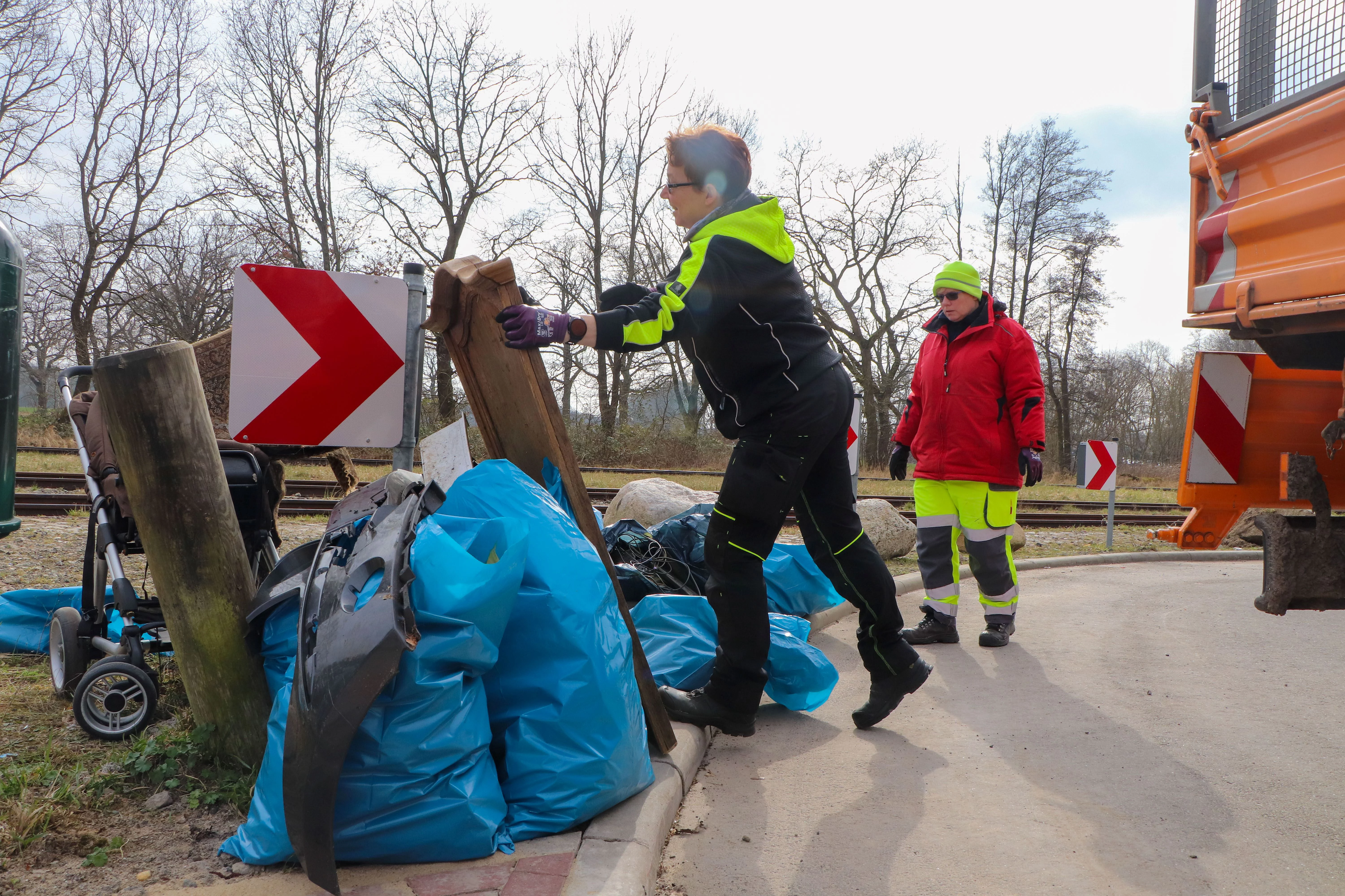 Müllsäcke werden auf die Ladefläche eines LKW geladen.