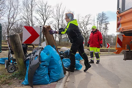 Müllsäcke werden auf die Ladefläche eines LKW geladen.