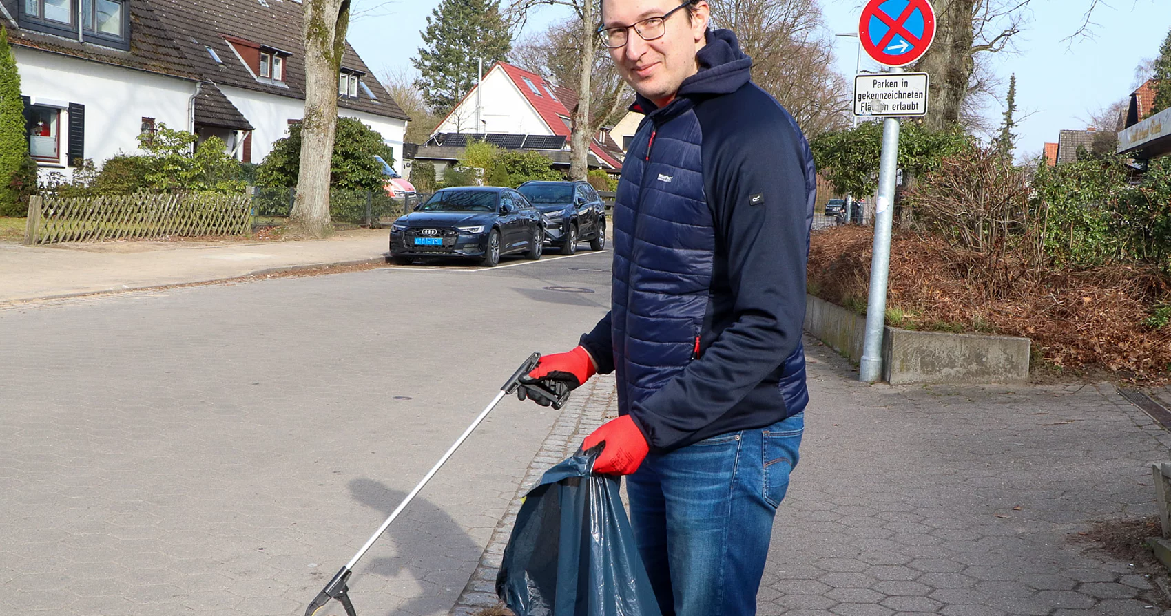 Der zukünftige Bürgermeister Patrick Klose mit einem Müllsack und einer Müllzange.
