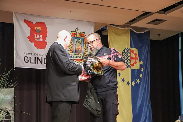 Von den befreundeten Feuerwehrleuten aus Carquefou gab es einen Helm als Geschenk für Wehrführer Michael Weidemann (l.) Foto: Stadt Glinde