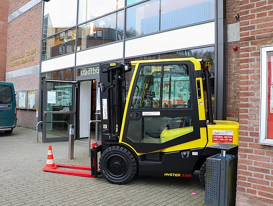 Ein Gabelstapler steht vor dem Bürgerhaus.