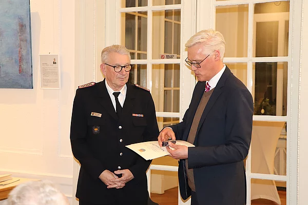 Karl-Heinz Fischer erhält von Bürgermeister Zug die goldene Ehrennadel.