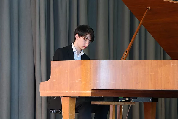 Ein junger Mann spielt Flügel. 