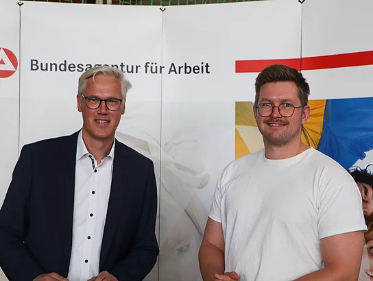 Zwei Menschen an einem Messestand.