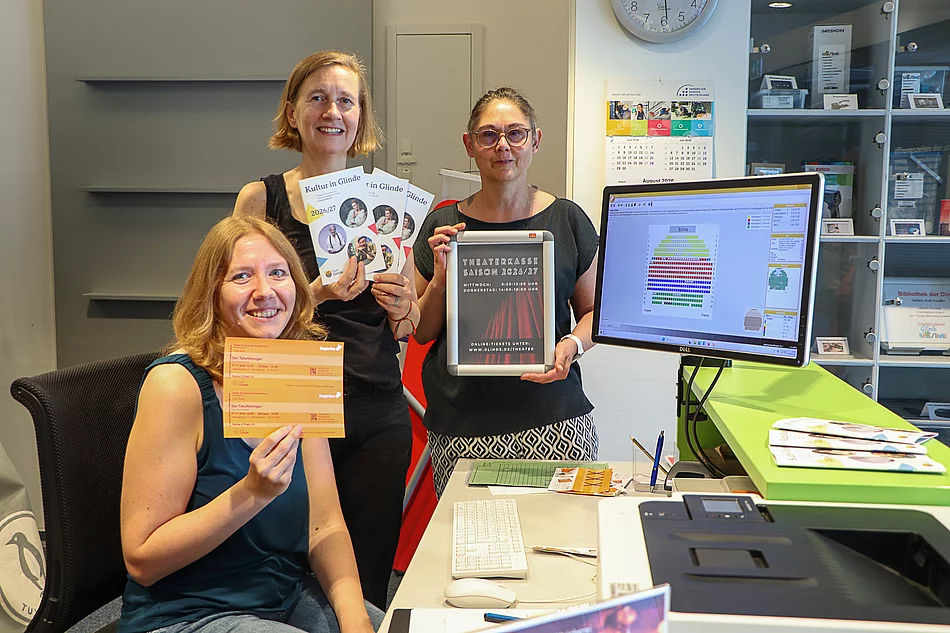 Vorverkauf für 'Theater im Forum' in der Stadtbücherei Glinde Drei Frauen stehen an einem Computerbildschirm auf dem der Saalplan eines Theaters zu sehen ist.