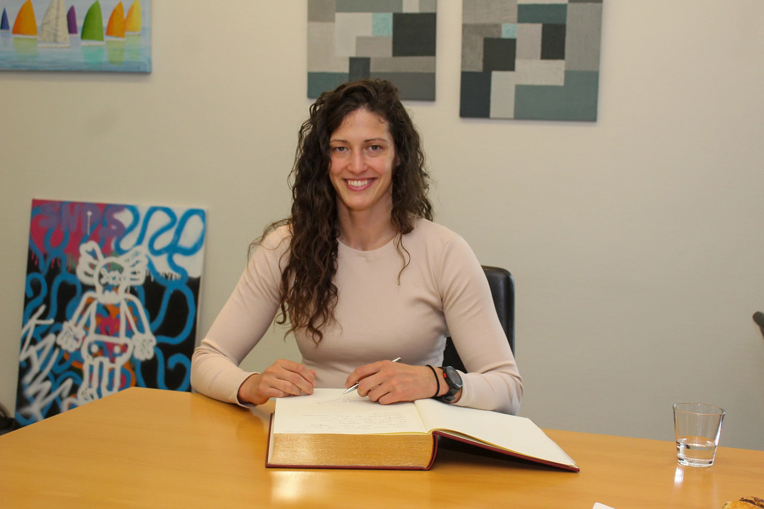 Judoka Miriam Butkereit hat das Goldene Buch der Stadt Glinde vor sich und einen Stift in der Hand.. 