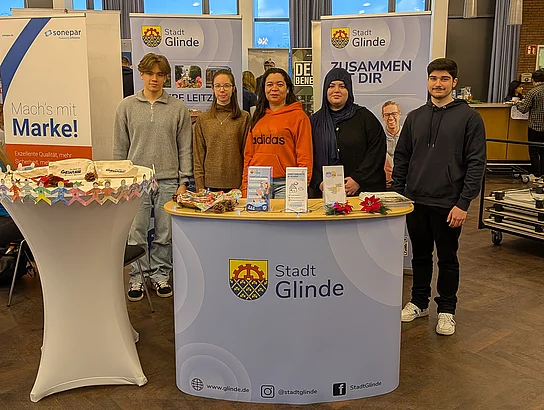 Junge Menschen stehen hinter einem Messestand der Stadt Glinde.