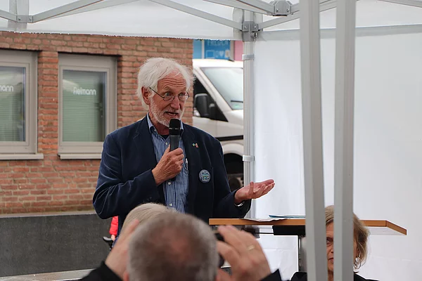 Fairtrade-Ehrenbotschafter Manfred Holz spricht in ein Mikrofon. 