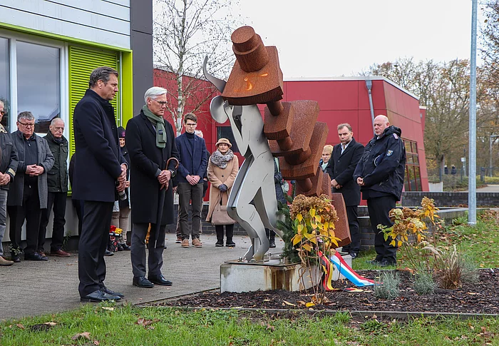 Menschen stehen am Mahnmal für das Zwangsarbeitslager Wiesenfeld.