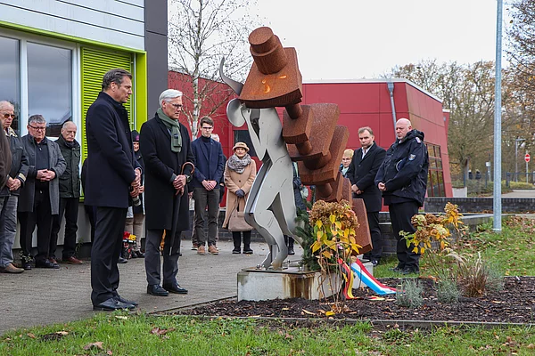 Menschen stehen am Mahnmal für das Zwangsarbeitslager Wiesenfeld.