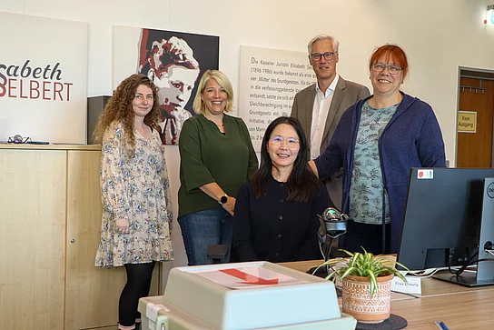 Gruppenfoto mit Team im Briefwahlbüro an einem Büroarbeitsplatz.