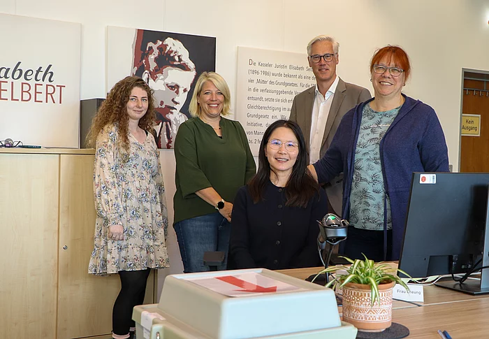 Gruppenfoto mit Team im Briefwahlbüro an einem Büroarbeitsplatz.