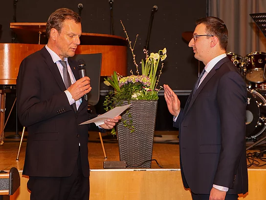 Bürgervorsteher Peters verliest einen Text während Patrick Klose die rechte Hand vor der Brust zum Eid erhoben hat.