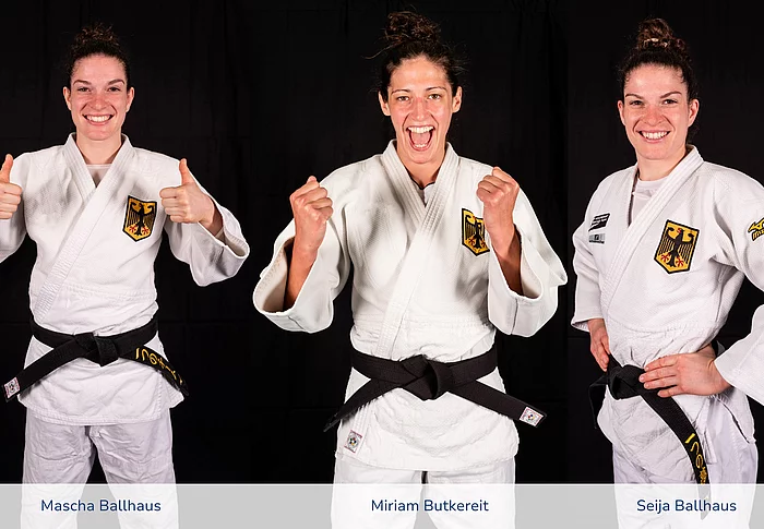 Drei Frauen mit dunkelen Haaren tragen einen Judo-Anzug und lächeln freundlich