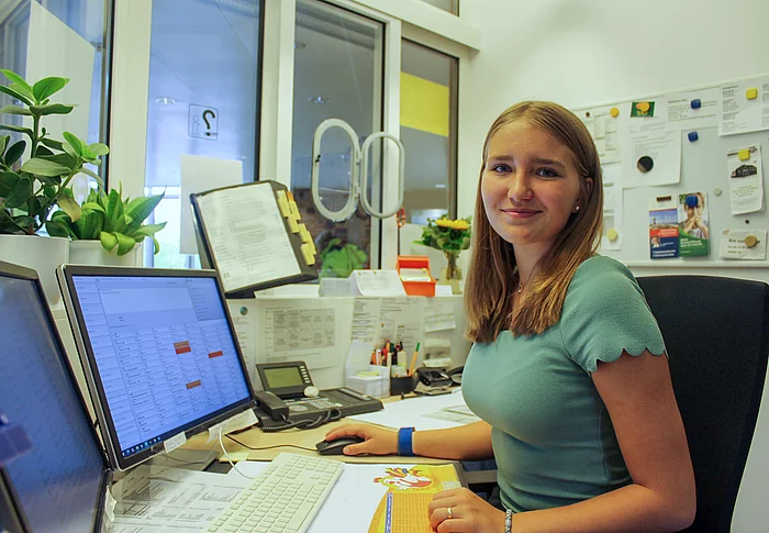 Praktikantin Aurelia Eisenberger sitzt vor einem Computer Bildschirm