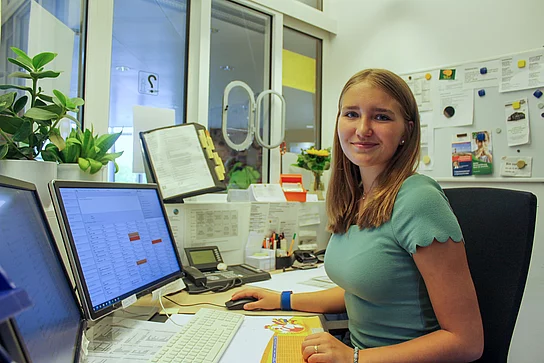 Praktikantin Aurelia Eisenberger sitzt vor einem Computer Bildschirm
