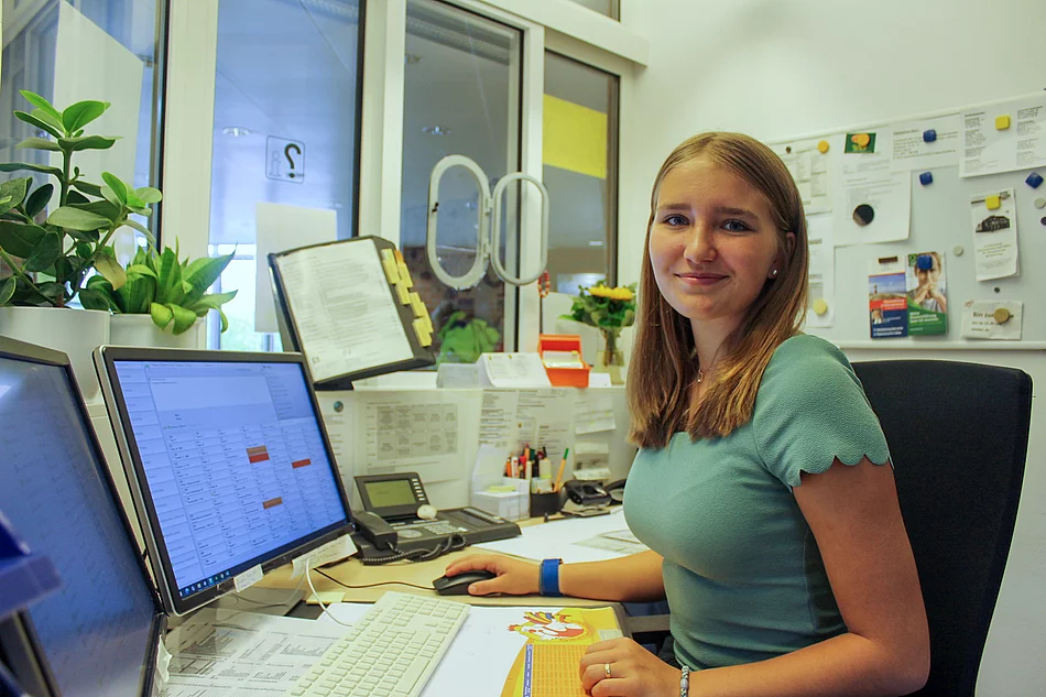 Praktikantin Aurelia Eisenberger an der Information Praktikantin Aurelia Eisenberger sitzt vor einem Computer Bildschirm