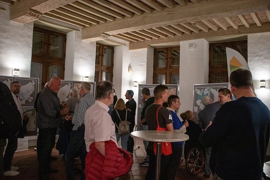 Menschen schauen auf Pinnwände mit Straßenkarten