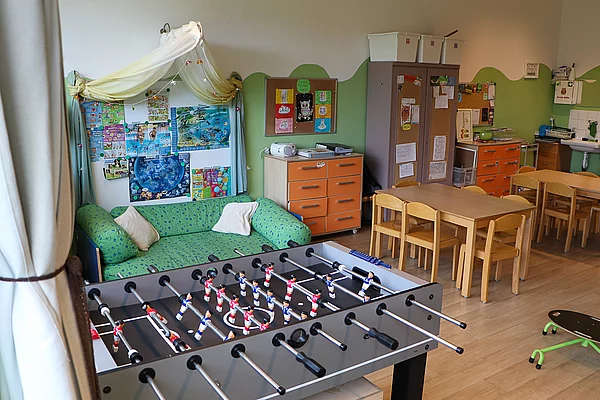 Ein Tischkicker und ein Sofa und ein Tisch mit Stühlen.