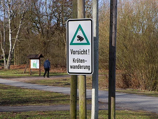 Auf einem Schild ist eine Kröte zu sehen mit den Worten "Vorsicht, Krötenwanderung"