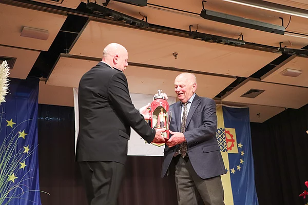Lothar Neinass (r. ehemaliges Amt Glinde) überreicht den Heiligen Antonius der in einem offenem Feuerlöscher steht. Foto: Stadt Glinde
