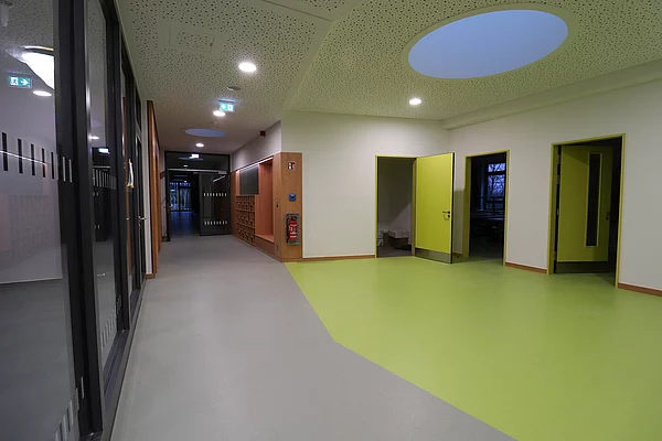 Der Boden im Obergeschoß ist in einen grauen und einen grünen Bereich geteilt. In der Decke gibt es ein rundes Oberlicht. 