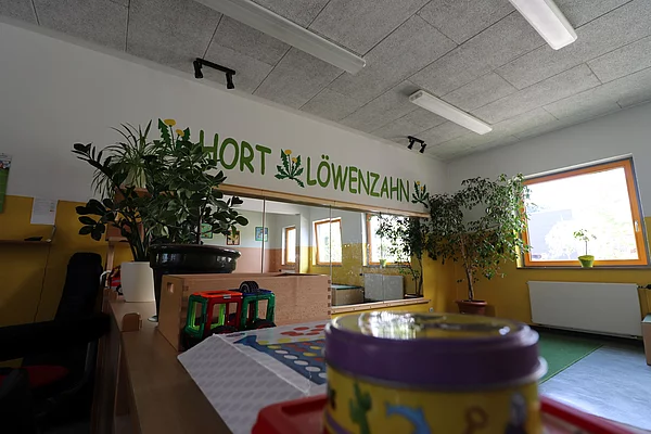 An einer Wand steht über einem großen Spiegel Hort Löwenzahn.
