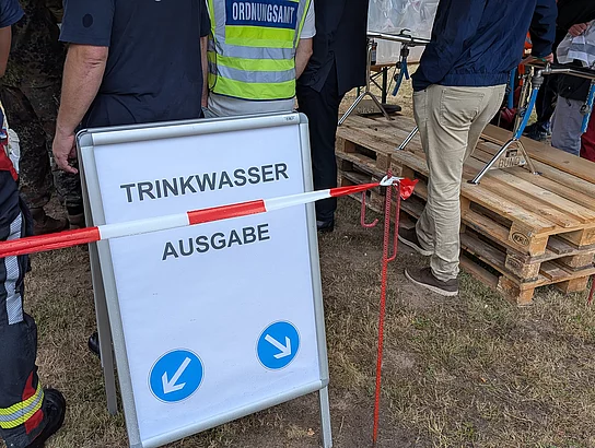 Ein Hinweisschild mit der Beschriftung "Trinkwasserausgabe"