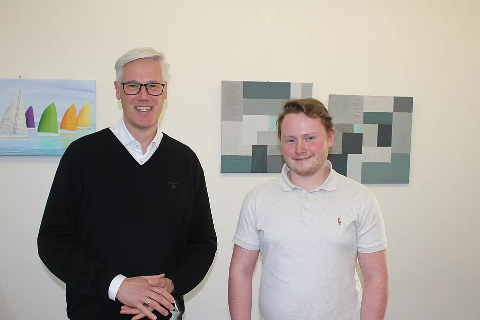 Bügermeister Rainhard Zug hat einen schwarzen Pullover an. Jonas Bartz trägt ein weißes Polo-Shirt.