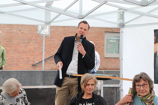 Glindes Bürgervorsteher Claus Peters spricht in ein Mikrofon