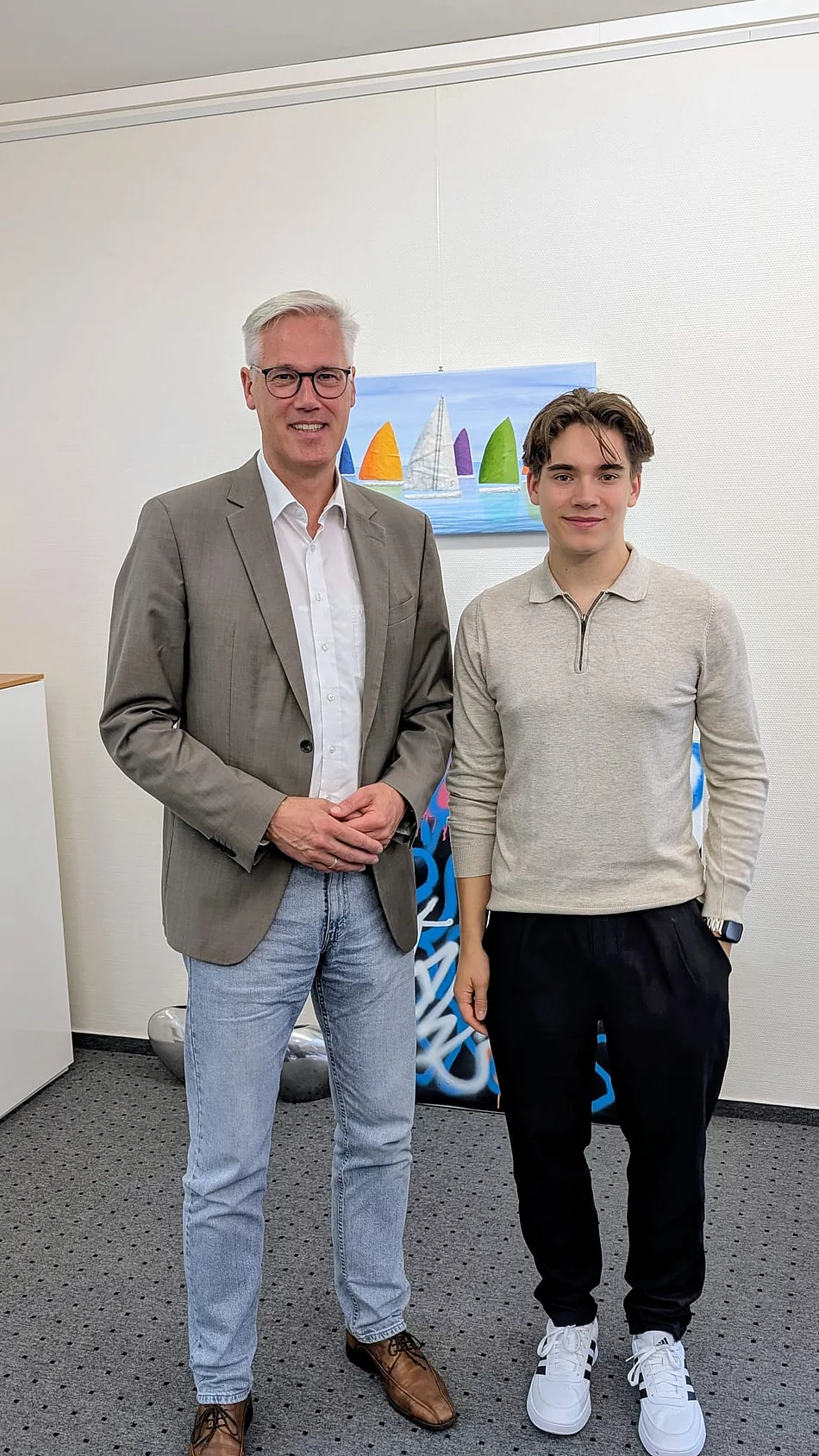 Bürgermeister Rainhard Zug steht neben einem jungen Mann.