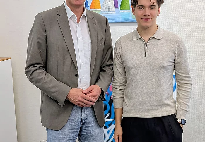Bürgermeister Rainhard Zug steht neben einem jungen Mann.