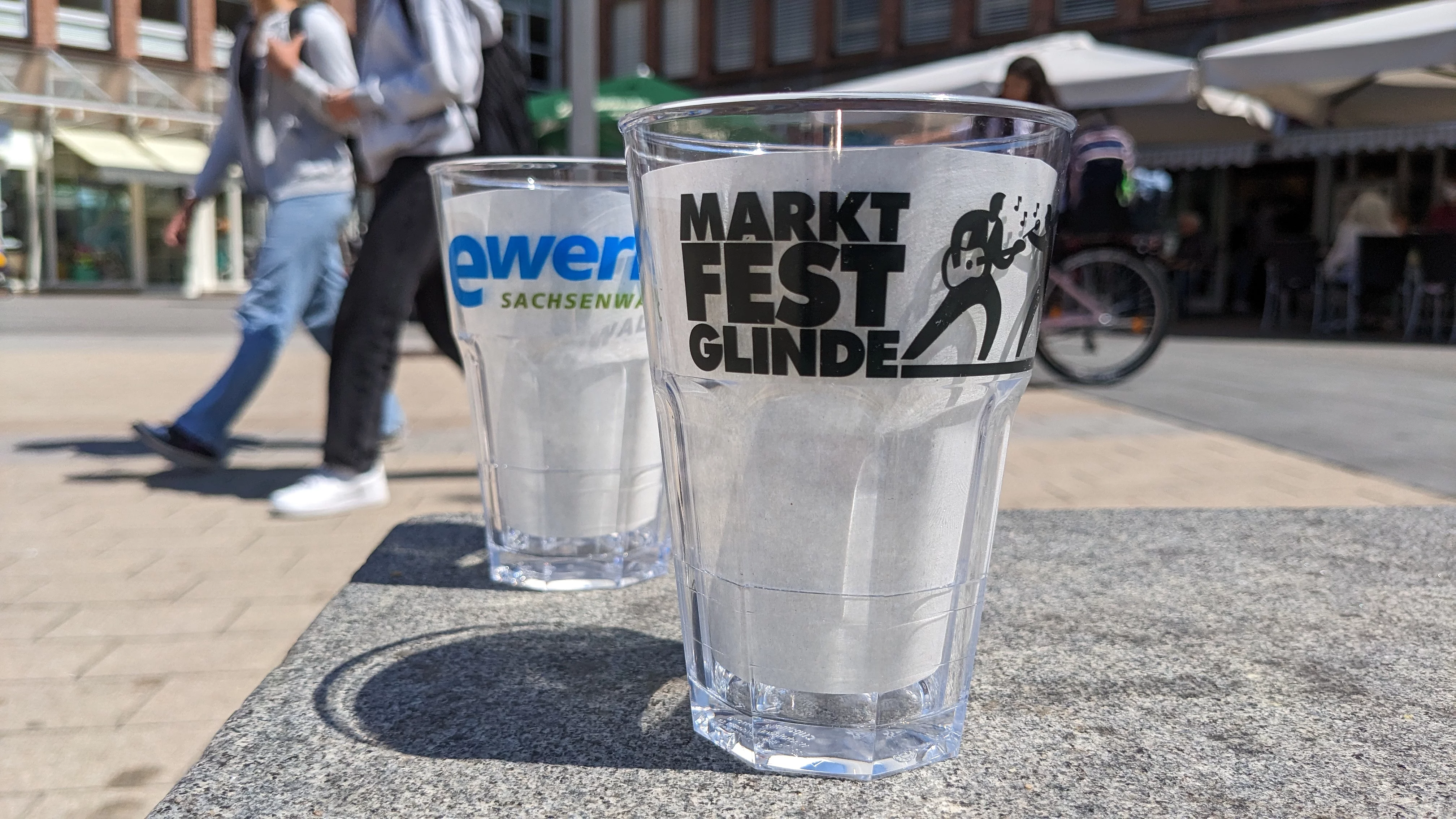 Zwei Plastikbecher mit Aufdruck Marktfest stehen auf dem Glinder Markt